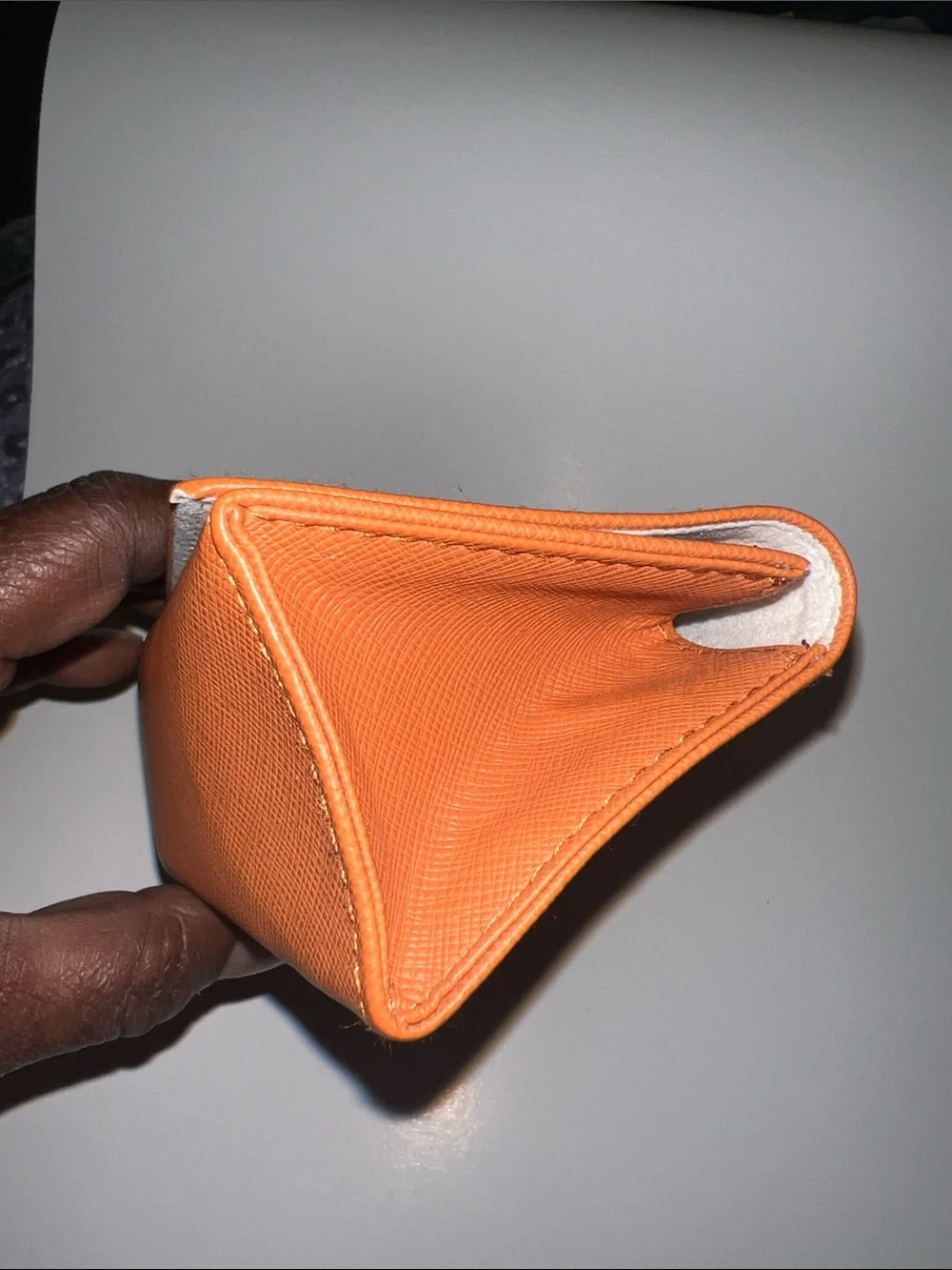 Tory Burch orange textured leather sunglasses case featuring a gold-tone logo